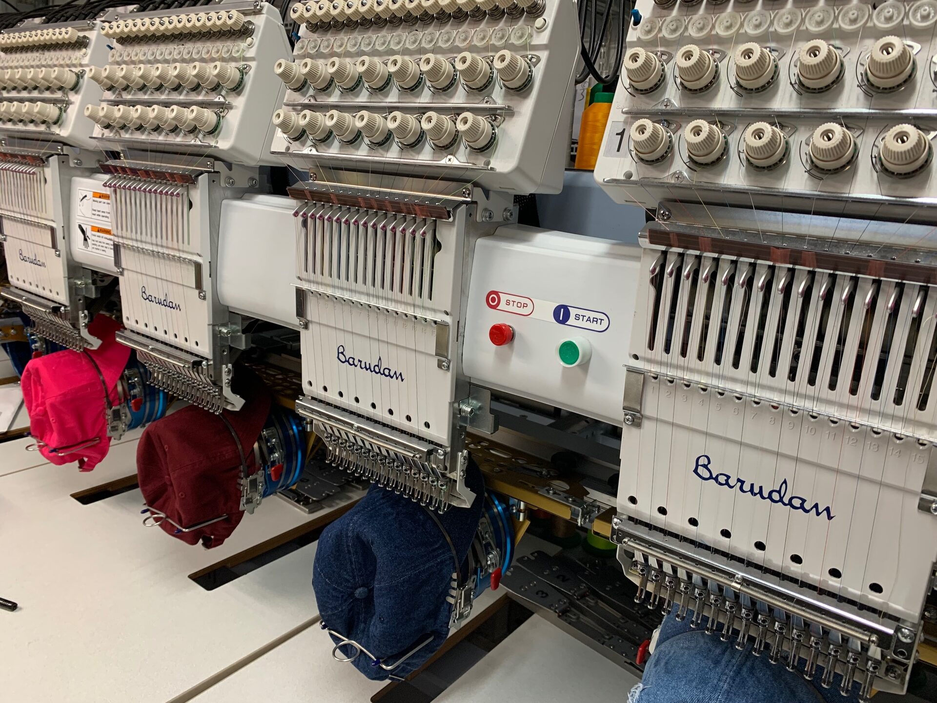 Multi-head commercial embroidery machines stitching a bulk order in our studio